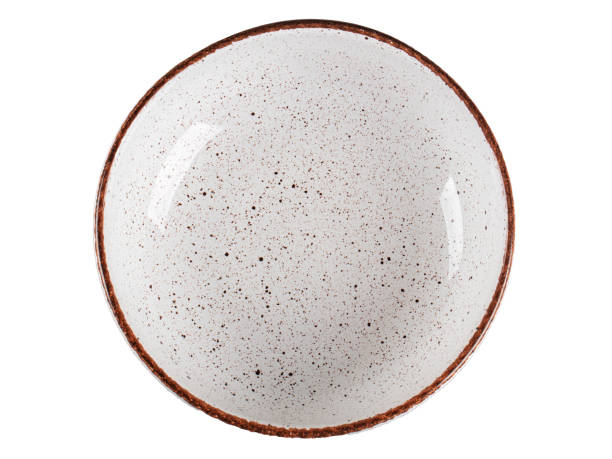 White ceramic plate with dark dots framed by a brown edging on a white background.