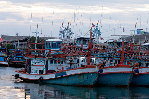 Many fishing boats are moored at the pier in the morning.