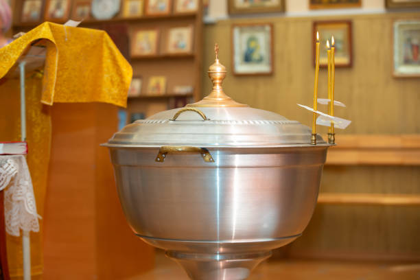 Young mother holding her baby boy during christening in an Orthodox church.