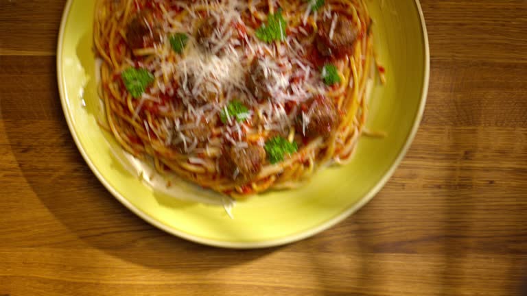 LD Placing a plate with spaghetti and meatballs onto the table