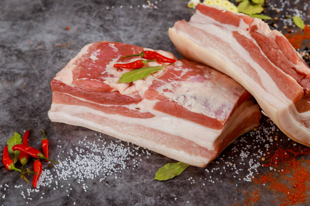 istock Two pieces of raw pork belly with garlic. 1887237471