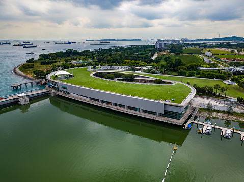Aeria view of the Marina Barrage and large amounts of international shipping outside the city of Singapore