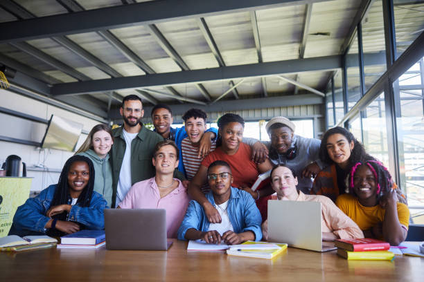 istock Smiling college teacher and his diverse class sitting in a school cafeteria 1887298375