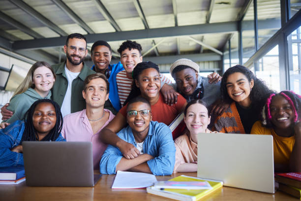 istock Smiling college teacher and his diverse class sitting in a cafeteria 1887300993