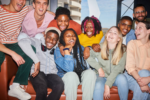 istock Diverse young college students and their teach laughing on a sofa at school 1887320399