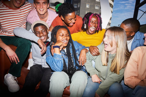istock Laughing group of diverse young college students sitting on a sofa at school 1887321925