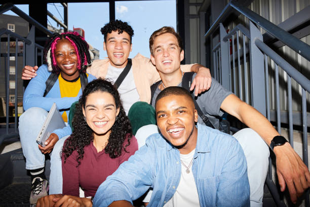 istock Diverse young college students sitting on steps at school and laughing 1887325022