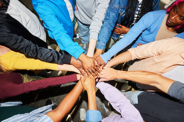 Diverse young college students standing with their hands together