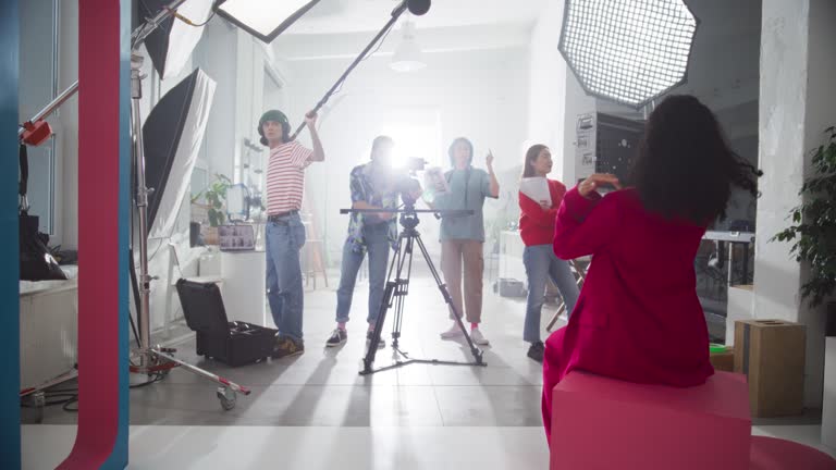 Behind the Scene Footage of a Commercial: Film Crew Working Together to Shoot an Aesthetic Video as Marketing Content. Dynamic Zoom Out Catching the Positive Energy of Young Video Creators