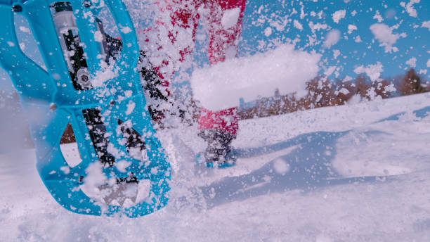 istock CLOSE UP, LOW ANGLE VIEW: Fresh snow flying behind lady running in snowshoes 1887368465