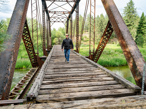 Man walks on an old rickety bridge