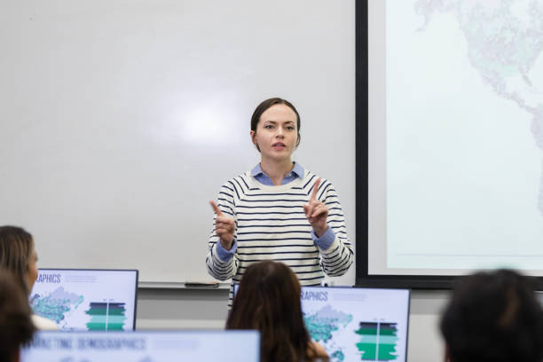 istock Young adult female professor teaches computer lab 1887375401