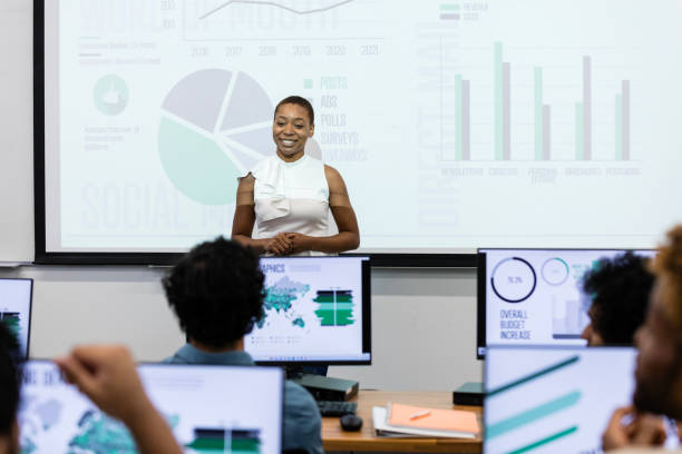 Guest female lecturer teaches class in college computer lab The young adult businesswoman is the guest lecturer in the university computer lab. teacher projector stock pictures, royalty-free photos & images