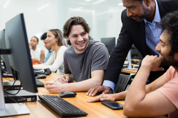 istock Male students joke as male teacher helps them with assignment 1887375712