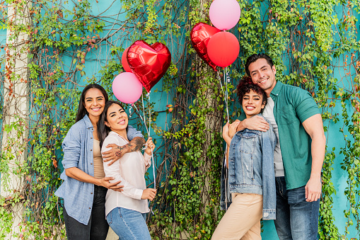 Portrait of lesbian couple and heterosexual couple celebrating Valentine's Day in the city