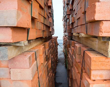 Fragment of pallets with packed red bricks.