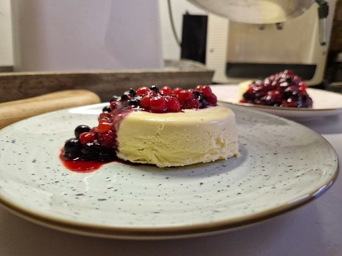Cheesecake with wild berries topping served on a plate.