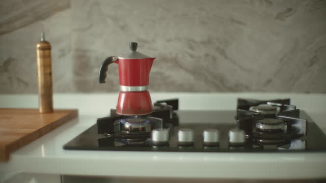 Man prepares coffee in a moka pot at home