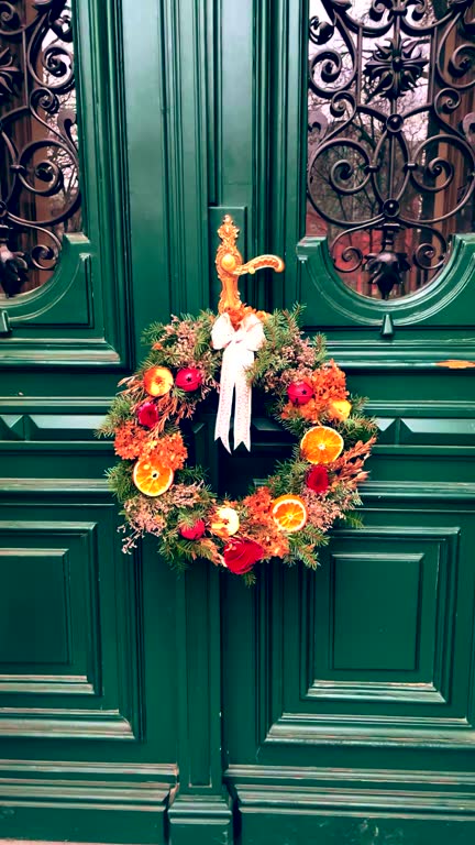 Christmas orange fruit decor wreath on a green door.