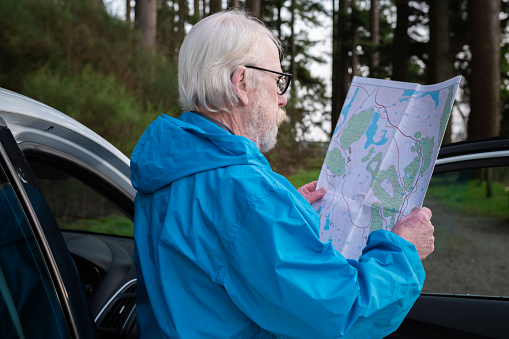 Side view of a senior man looking at his map on an overcast winter day in rural Scotland