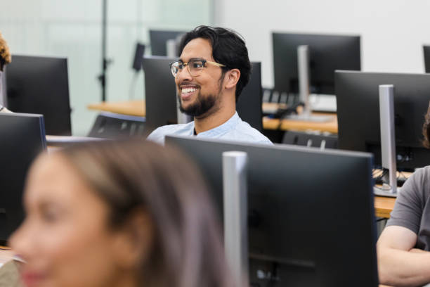 istock Young adult male student smiles during class 1887419876