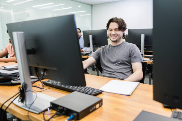 istock Young adult male student smiles while working on a project in the lab 1887420406