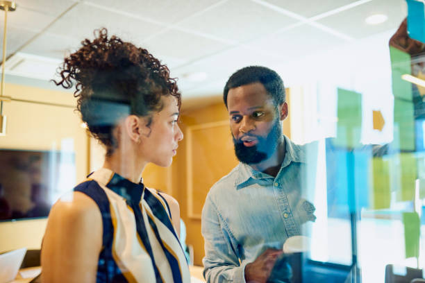 istock Diverse Colleagues Brainstorming on Glass Wall 1887444235