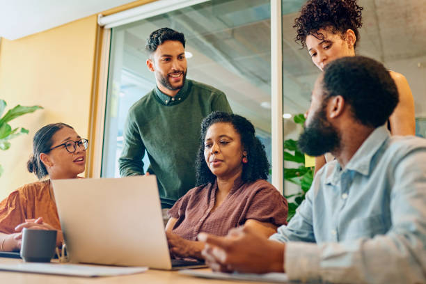 istock Diverse Colleagues Gathered Around Laptop Smiling 1887444760