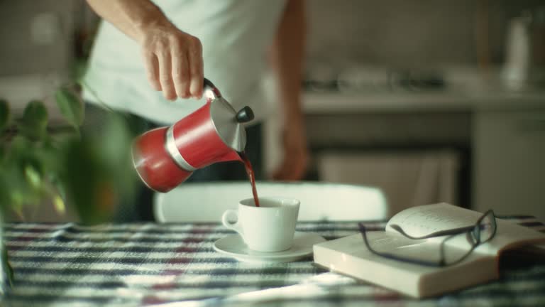 Man prepares coffee in a moka pot at home