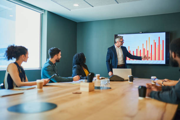 Business meeting Diverse business team sitting around a conference table having a meeting and discussing financial data. growth in sales stock pictures, royalty-free photos & images