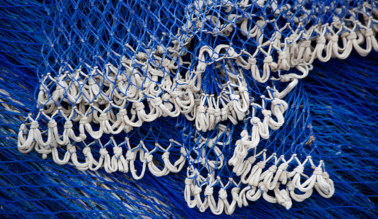 Close-up of a blue and white net piled up in the harbor