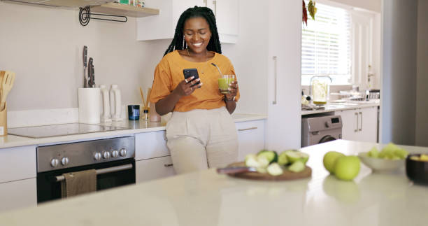 istock Young woman using a smartphone in the kitchen 1887470329