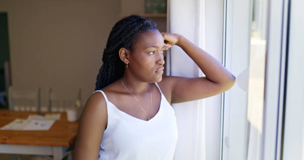 istock Young Woman Looking Out Window 1887470901