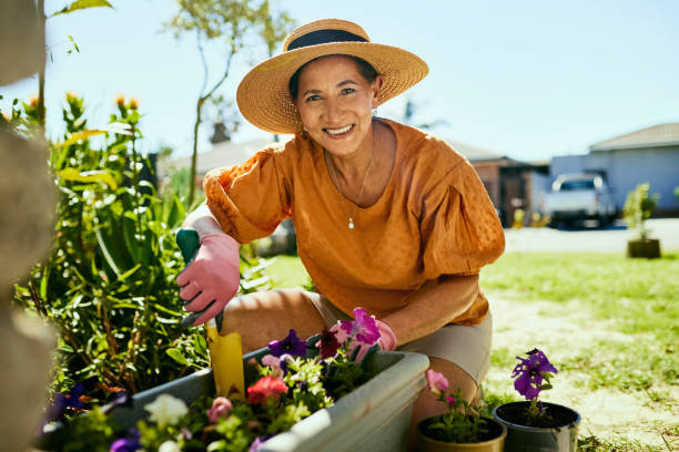 šťastná žena zahradničení na svém dvorku - aktivní senioři - stock snímky, obrázky a fotky