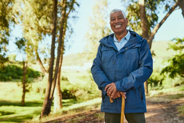 istock Senior Man Smiling While Leaning On His Walking Stick In The Forest 1887472001
