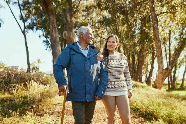 istock Elderly Couple Walking in the Park, Smiling and Holding Hands 1887472015
