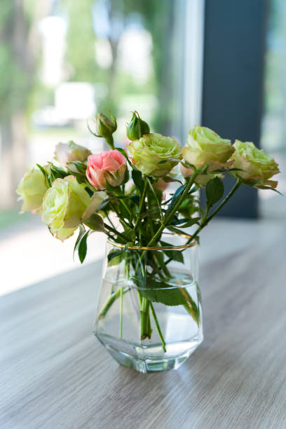 istock Green roses in a vase on a table in a cafe. Close-up. Selective focus. 1887503849