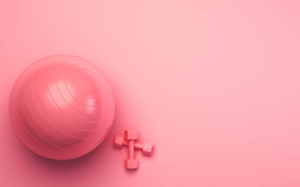 istock Pink Pilates Ball and Dumbbell Set on Pink Soft Background 1887511103