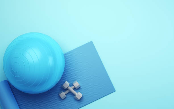 istock Turquoise Pilates Ball Blue Exercise Mat and Gray Dumbbell Set on Blue Soft Background 1887522675