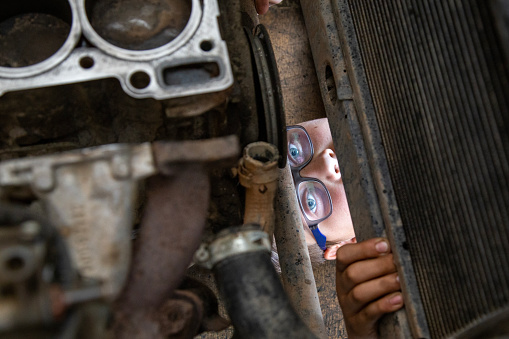 Karaman,Turkey,August 2, 2016: Eyes and glasses of a young man repairing automobiles