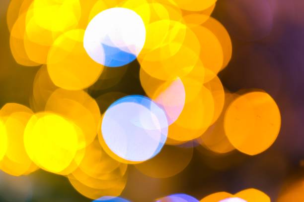 A mesmerizing image captures the enchanting glow of blurred lights on a Christmas tree, creating a warm and festive ambiance.