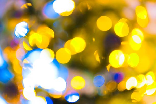 A mesmerizing image captures the enchanting glow of blurred lights on a Christmas tree, creating a warm and festive ambiance.