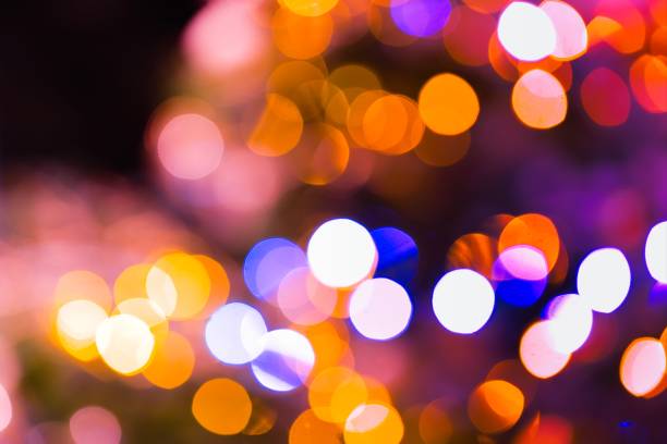 A mesmerizing image captures the enchanting glow of blurred lights on a Christmas tree, creating a warm and festive ambiance.