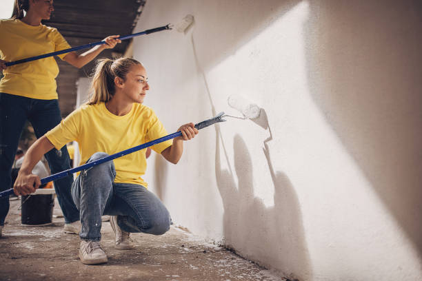 istock Volunteers painting building wall 1887583785