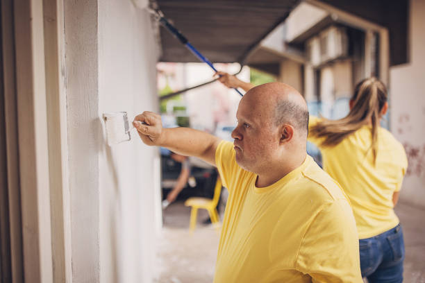 istock Volunteers painting building wall 1887591059