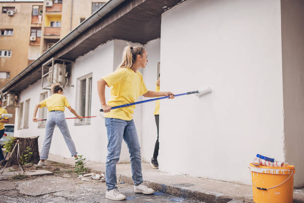 istock Volunteers painting building wall 1887596213