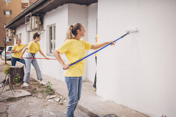 istock Volunteers painting building wall 1887598855