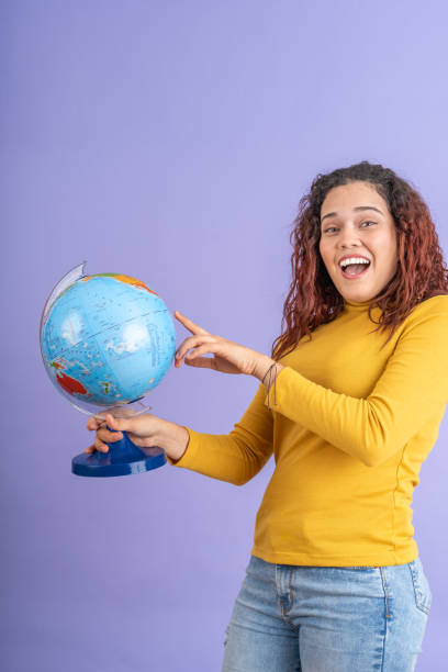 istock Young woman pointing at a terrestrial globe 1887654816