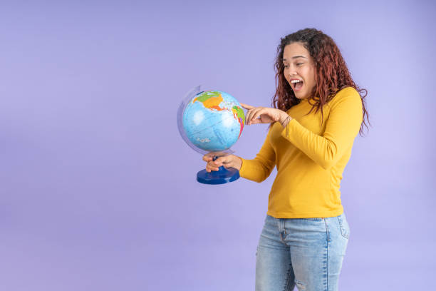 istock Young woman looking for countries on a globe 1887657032