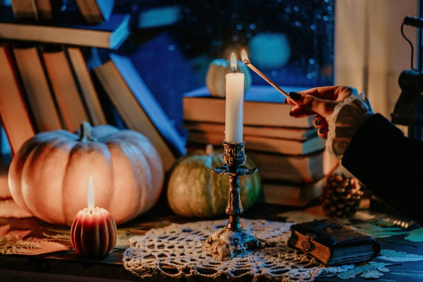 istock Rich retro dressed woman hand lights candle, bronze candlestick with long match 1887666111